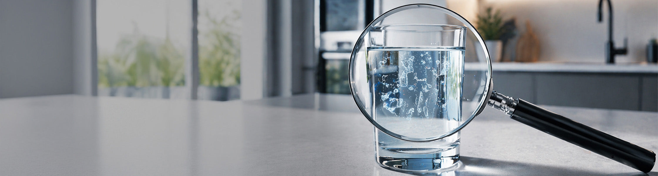 Klar2O Trinkwasseranalyse mit Lupe über Wasserglas zur Sichtprüfung von Schwebstoffen, Mikroplastik und Wasserqualität.